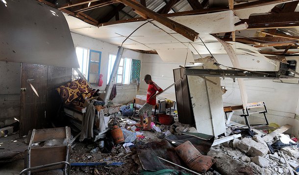 Palestinian men inspect the damage at a UN school at the Jabalia refugee camp in the northern Gaza Strip after the area was hit by Israeli shelling on July 30, 2014. Israeli bombardments early on July 30 killed "dozens" of Palestinians in Gaza, including 