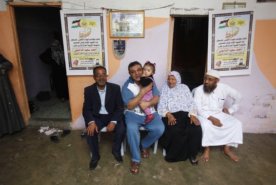 Freed Palestinian prisoner Ahmed al-Damoni (2nd L), who was held by Israel for 23 years, holds his niece as he sits next to his mother (2nd R) and relatives inside his family's house in the central Gaza Strip October 30, 2013. Israelis say al-Damoni was c