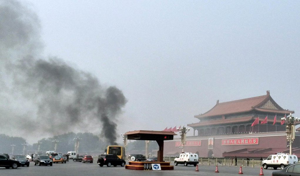 Vehicles travel along Chang'an Avenue as smoke raises in front of a portrait of late Chinese Chairman Mao Zedong at Tiananmen Square in Beijing October 28, 2013. Three people were killed and many injured on Monday, police said, when a car ploughed into pe