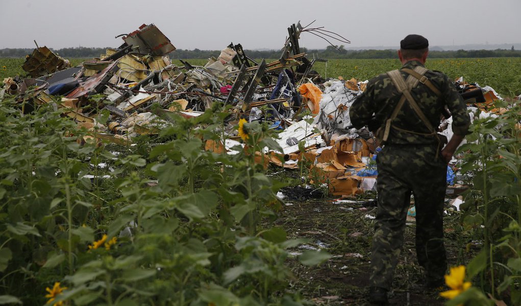 A pro-Russian separatist looks at wreckage from the nose section of a Malaysia Airlines Boeing 777 plane which was downed near the village of Rozsypne, in the Donetsk region July 18, 2014. World leaders demanded an international investigation into the sho