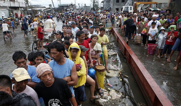 Typhoon victims queue for free rice at a businessman's warehouse in Tacloban city, which was battered by Typhoon Haiyan, in central Philippines November 12, 2013. Rescue workers tried to reach towns and villages in the central Philippines on Tuesday that 
