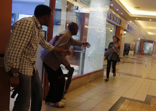 Armed police guide a woman carrying a child to safety as they hunt gunmen who went on a shooting spree at Westgate shopping centre in Nairobi, September 21, 2013. The gunmen stormed the shopping mall in Nairobi on Saturday killing at least 20 people in wh