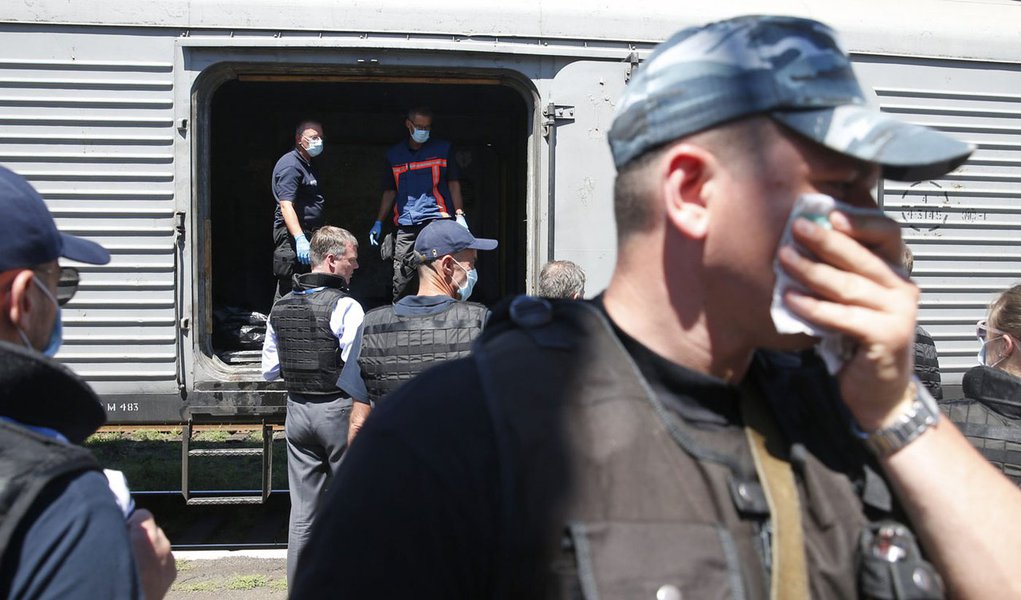 Monitores internacionais e especialistas forenses inspecionam os restos mortais das vÃ­timas da queda do aviÃ£o da Malaysia Airlines em um vagÃ£o refrigerado estacionado em uma ferroviÃ¡ria em Torez, na UcrÃ¢nia, nesta segunda-feira. 21/07/2014 REUTERS/Ma
