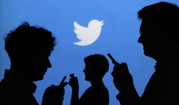 People holding mobile phones are silhouetted against a backdrop projected with the Twitter logo in this illustration picture taken in  Warsaw September 27, 2013. Twitter Inc, the eight-year-old online messaging service, gave potential investors their firs