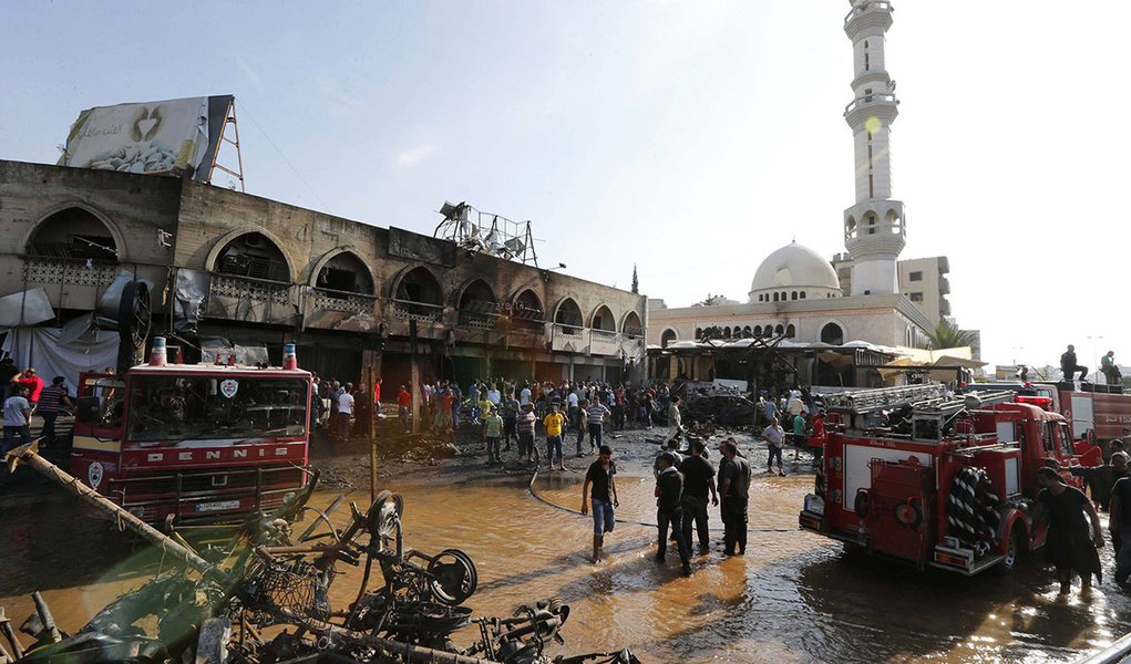 Civil Defence members and residents gather at the site of one of two mosques hit by explosions in Lebanon's northern city of Tripoli, August 23, 2013. Twin explosions outside two mosques killed at least 27 people and wounded hundreds in apparently coordin