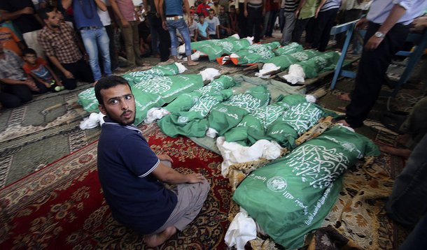 Homem senta ao lado dos corpos da famÃ­lia Abu Jama, que segundo os mÃ©dicos foram vÃ­timas de um ataque aÃ©reo de Israel, em uma mesquita de Khan Younis, no sul da Faixa de Gaza. 21/07/2014. REUTERS/Ibraheem Abu Mustafa