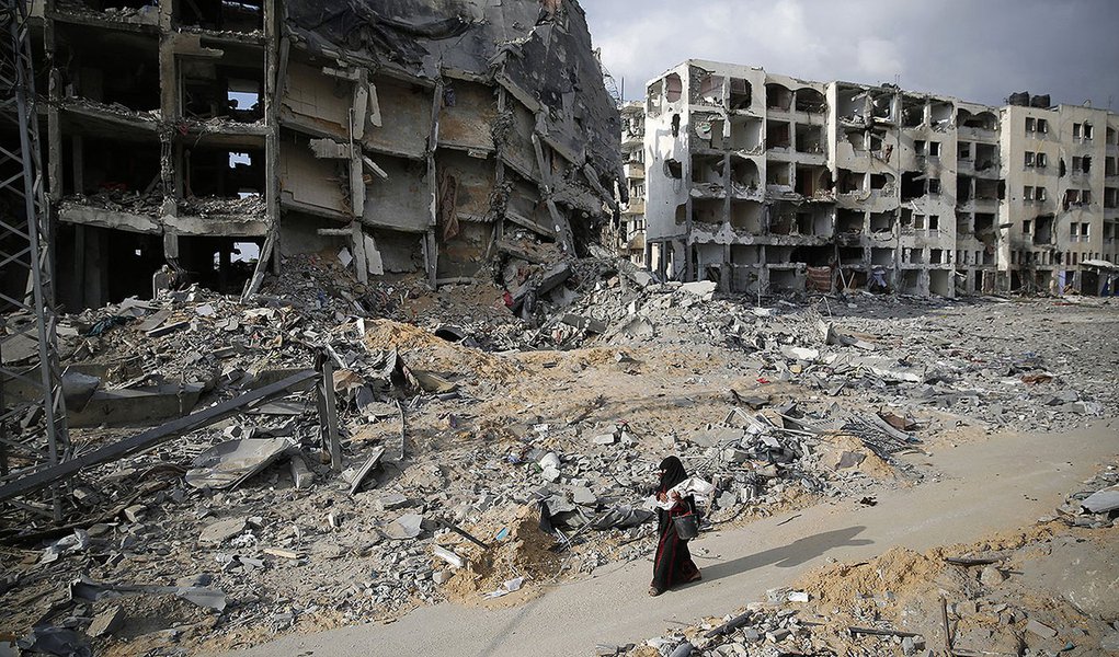 Palestina passa por prÃ©dios destruÃ­dos em Beit Lahiya, no norte da Faixa de Gaza. 03/08/2014 REUTERS/Finbarr O'Reilly