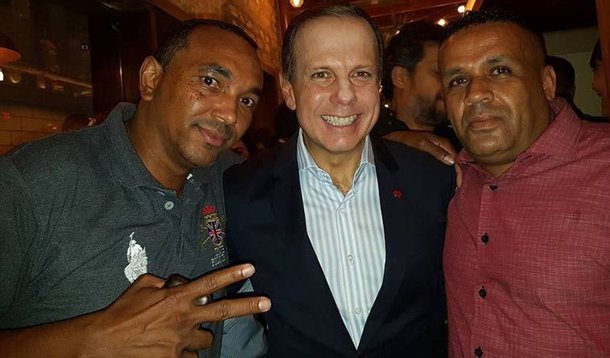 O ex-prefeito de São Paulo e pré-candidato a governador paulista, João Doria (PSDB), posou para foto ao lado de Ananias Pereira (de camisa vermelha), coordenador do Movimento Social de Luta pela Moradia (MSLM) que ocupava o edifício que desabou no centro de São Paulo; nesta semana, o tucano afirmou que o local era ocupado por uma facção criminosa. O tucano, no entanto, não deu explicações sobre a acusação;​ "O prédio foi invadido e parte desta invasão financiada e ocupada por uma facção criminosa", disse 