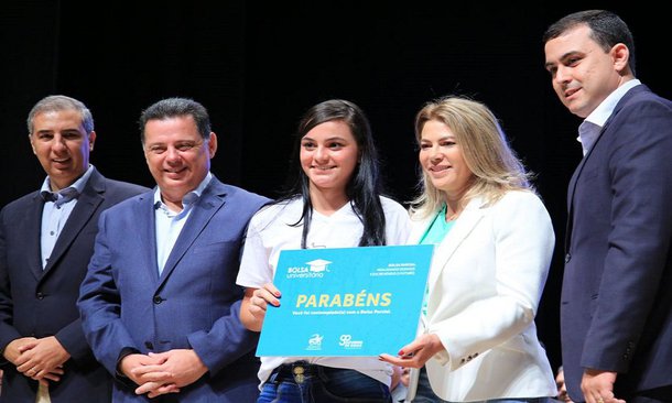 Com galerias do Teatro Rio Vermelho do Centro de Cultura e Convenções de Goiânia lotadas, o governador Marconi Perillo e a primeira-dama Valéria Perillo comandaram a assinatura de novos contratos do programa Bolsa Universitária, com inclusão de mais 7 mil alunos e abertura de inscrição para mais 10 mil beneficiários; assim, o governo atinge a marca de 187.300 estudantes beneficiados com o programa; idealizador do programa, Marconi saudou os novos beneficiários dizendo que “governar é escolher prioridades” e o programa Bolsa Universitária, fora o custeio da máquina, é a “prioridade número” do governo