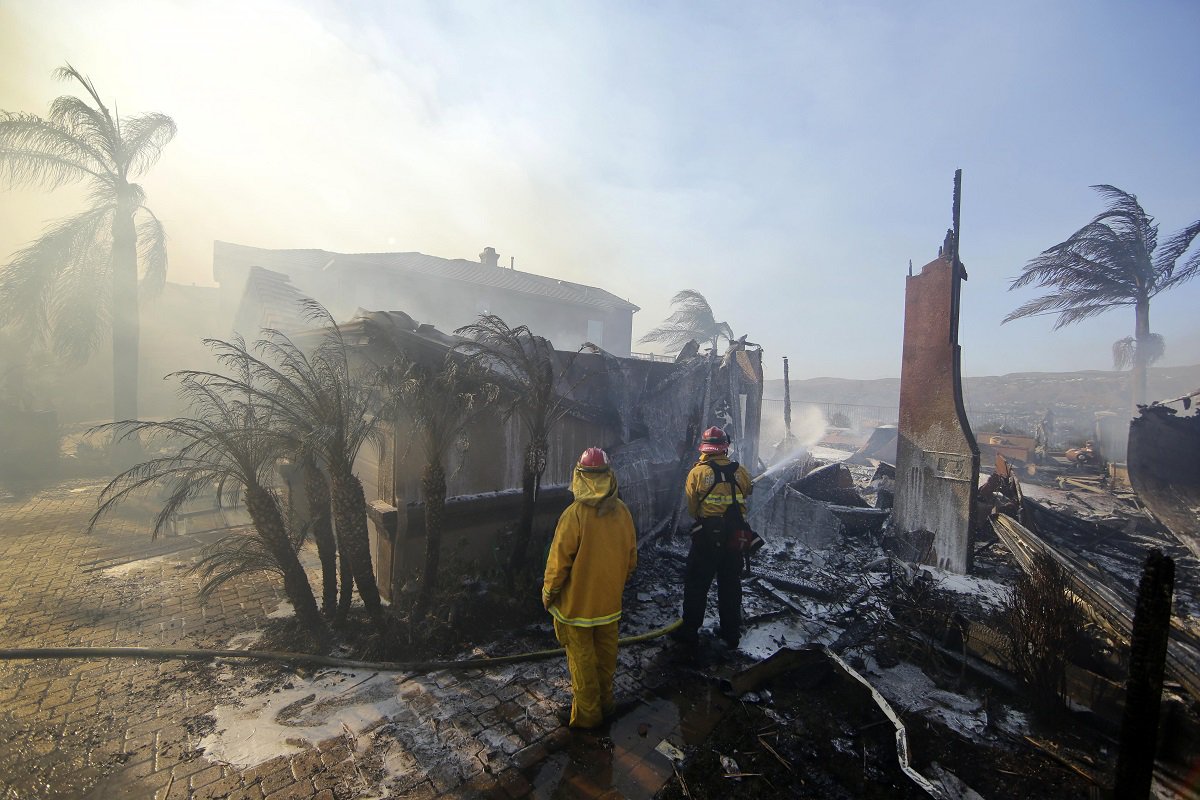 epaselect epa06255521 A firefighter puts water on a home destroyed by the Canyon Fire No. 2 in Anaheim Hills, California, USA, 09 October 2017. The Canyon Fire 2 has spread to several thousand acres and is zero percent contained. EPA/PAUL BUCK