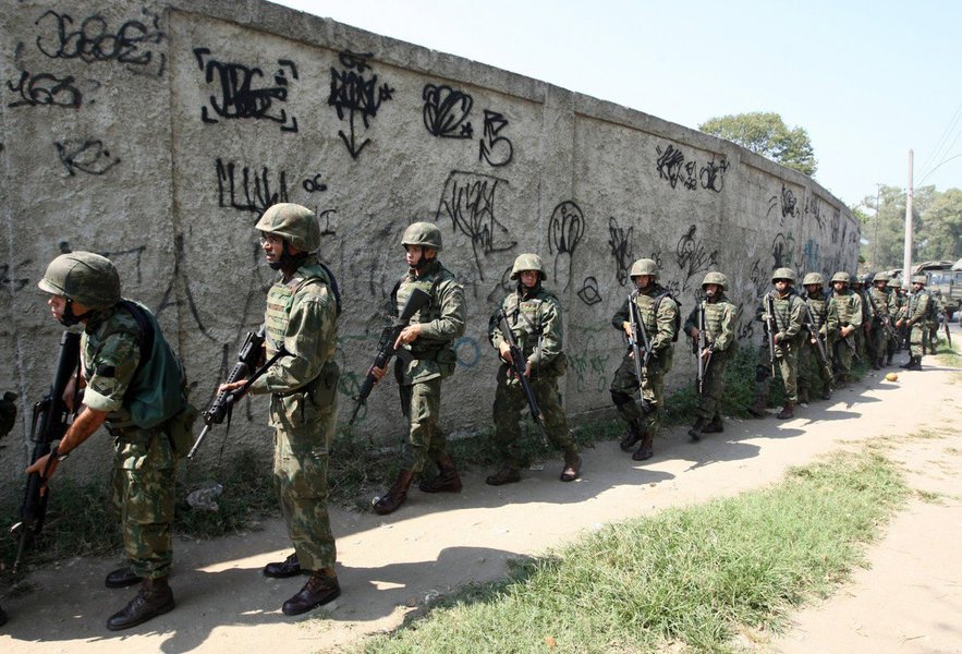 Um novo tiroteio foi ouvido na madrugada de hoje (23) na comunidade da Rocinha, na zona sul do Rio de Janeiro; de acordo com a Assessoria de Comunicação Social do Estado-Maior Conjunto das Operações em Apoio ao Plano Nacional de Segurança Pública, por volta das 4h30, elementos armados tentaram romper bloqueio do cerco estabelecido pelas Forças Armadas nas proximidades da Rua General Olímpio Mourão Filho; na operação, foram presos pela Polícia do Exército os cinco ocupantes de um veículo Renault Symbol e apreendidos um fuzil AK47 calibre 7,62mm com numeração raspada e quatro carregadores