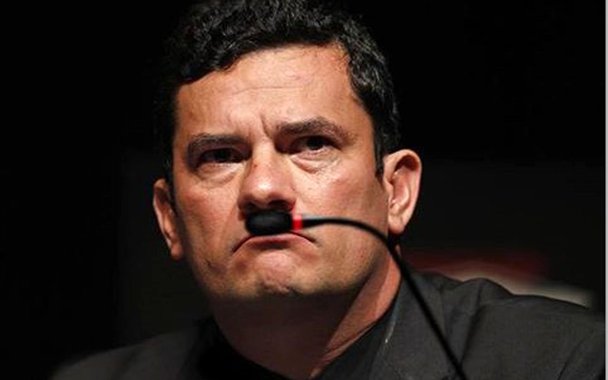 Uma foto do juiz Sérgio Moro com um pequeno microfone preto na direção do buço, que o faz lembrar a figura de Hitler, viralizou nas redes; a imagem tem a assinatura do chargista Jota Camelo