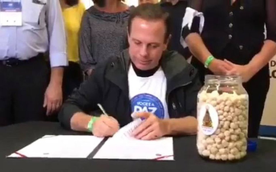 Jornalista Pedro Durán, da CBN, revela que a empresa responsável por produzir o produto chamado pelo prefeito João Doria de "abençoado" e que seria capaz de suprir necessidade de pessoas desnutridas não tem fábrica em atividade e nem capacidade de produzir em escala; "A dona da empresa diz que chegou a ter uma fábrica, mas ninguém sabe, ninguém viu. Empresa licenciada para produzir alimento secreta? Tem Serviço de Inspeção Federal? Tem Vigilância Sanitária? Não existe nada, é só um factóride, é como a clássica 'Fantástica Fábrica de Chocolate', um produto da fantasia marqueteira do 'prefake'", critica o jornalista Fernando Brito 