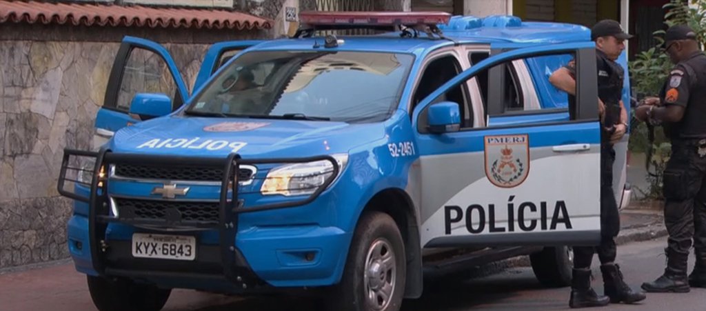 A operação Dark of the City, deflagrada na região metropolitana do Rio de Janeiro, cumpriu 22 mandados de prisão e prendeu oito pessoas em flagrante; houve tiroteio entre policiais e traficantes na comunidade da Grota, em Niterói, e um suspeito foi morto no confronto, segundo a Polícia Militar; a operação é resultado de investigação de mais de dois anos, que apura relações criminosas entre policiais militares e traficantes