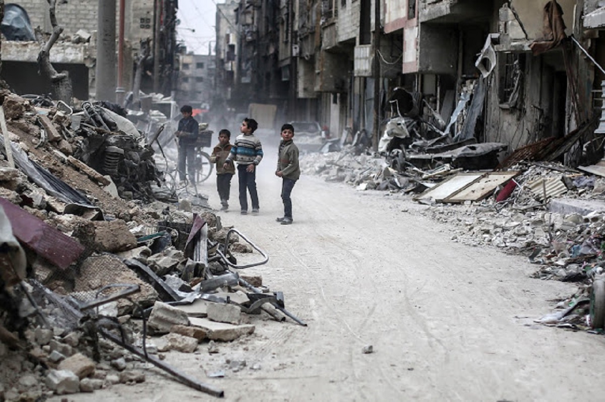 epa05821189 Children stand between the rubble, rebel-held Douma, Syria, 28 February 2017. The rubble are for buildings hit by airstrikes on 25 February 2017. EPA/MOHAMMED BADRA