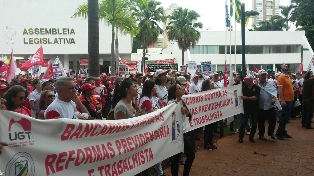 Primeiras movimentações de trabalhadores dentro da greve geral desta sexta-feira já começaram a acontecer; maior concentração de trabalhadores vai acontecer em frente à Assembleia Legislativa, no Centro da Capital; centenas de trabalhadores, de diversos órgãos e sindicatos, já estão no local protestando contra o governo de Michel Temer; cartazes mostram frases contra a reforma da Previdência e o massacre dos direitos dos trabalhadores; CUT espera reunir cerca de 3 mil trabalhadores no ato de hoje; em Anápolis, estudantes da UEG fecharam uma pista da BR-060 na manhã de hoje