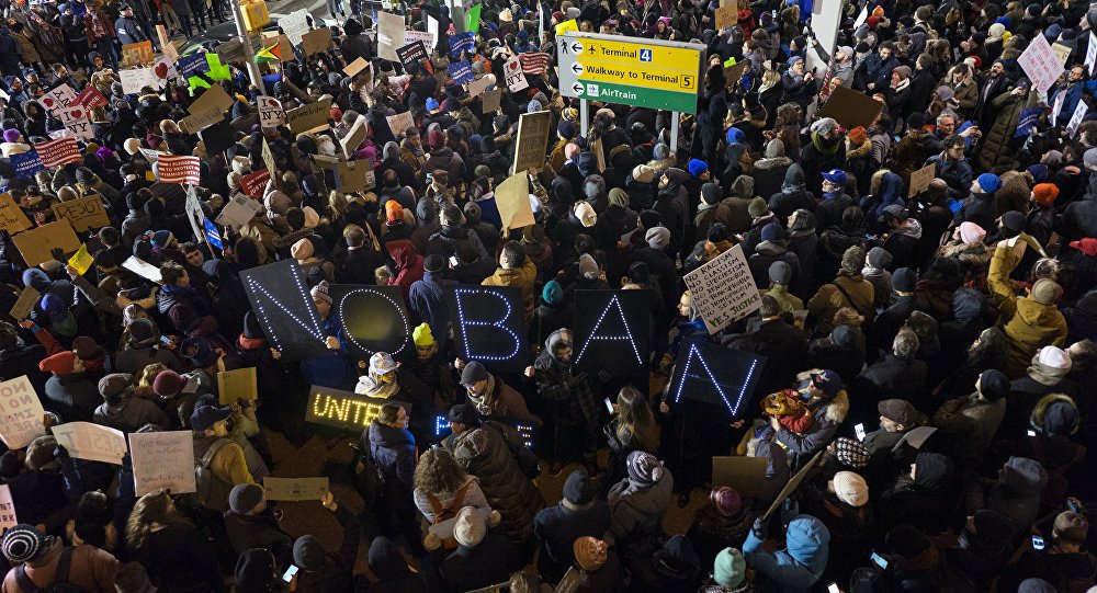 Centenas de manifestantes se reuniram em frente ao aeroporto JFK, em Nova York, para protestar contra o decreto de Donald Trump que proíbe entrada de refugiados e imigrantes de sete países muçulmanos nos EUA; com faixas que diziam frases como "Deixe meus amigos aqui" e "Sem ódio, sem medo, refugiados são bem-vindos aqui", os manifestantes prestaram solidariedade aos imigrantes atingidos pelo decreto da administração Trump, que horas depois foi suspenso por decisão da Justiça Federal dos Estados Unidos 