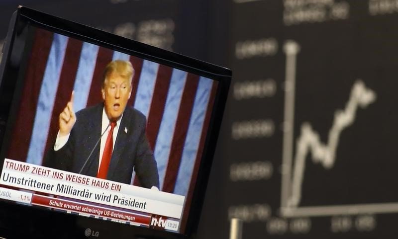 A TV screen showing U.S. President-elect Donald Trump is pictured in front of the German share price index, DAX board, at the stock exchange in Frankfurt, Germany, November 9, 2016. REUTERS/Staff/Remote