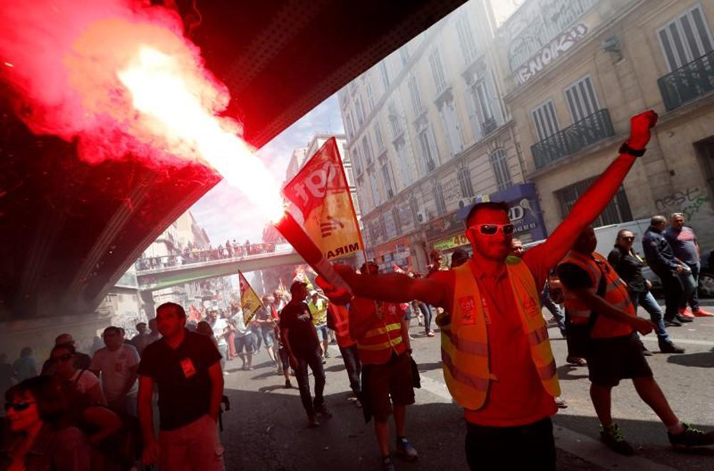Dezenas de milhares de pessoas protestaram em Paris contra uma proposta de reforma de leis trabalhistas que facilitaria contratações e demissões; jovens mascarados e encapuzados se envolveram em batalhas recorrentes com o batalhão de choque; manifestantes destruíram vitrines de lojas e atiraram projéteis contra os policiais; governo do presidente francês, François Hollande, se recusou a descartar a reforma, que foi aprovada na Assembleia Nacional por meio de um decreto no mês passado e que quer sancionar a legislação em julho