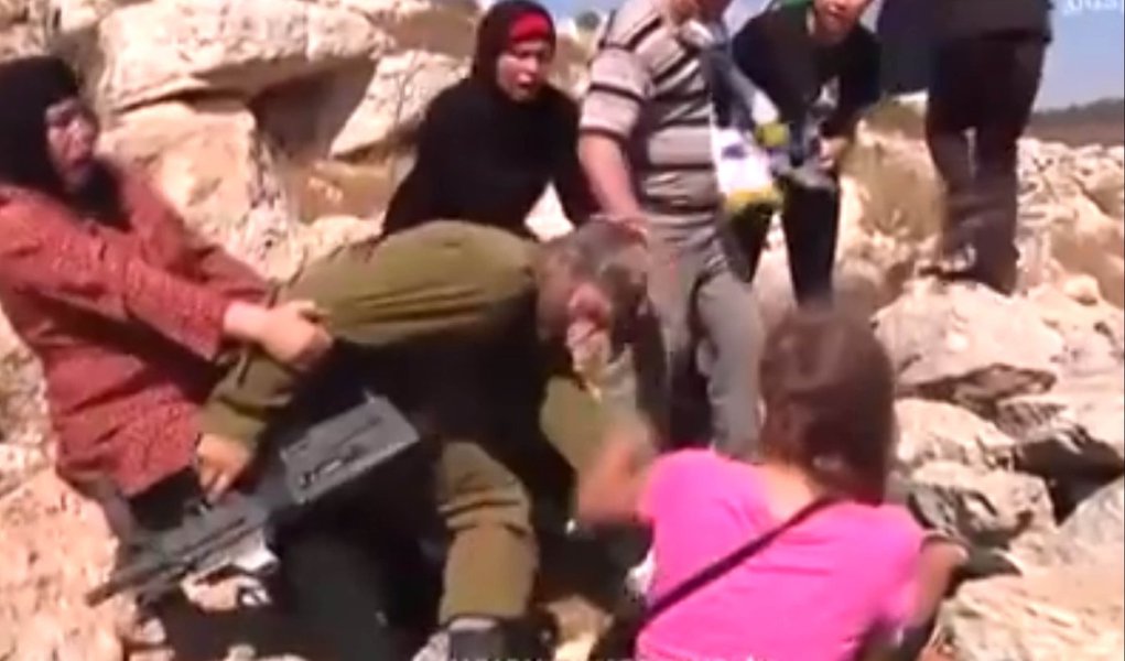 Imagens mostram um soldado tentando imobilizar com estrangulamento o garoto Mohamed Tamimi, de 12 anos, quando é cercado pela mãe, a tia e a irmã do adolescente; elas puxam e batem no militar até conseguirem libertar o menino; assista