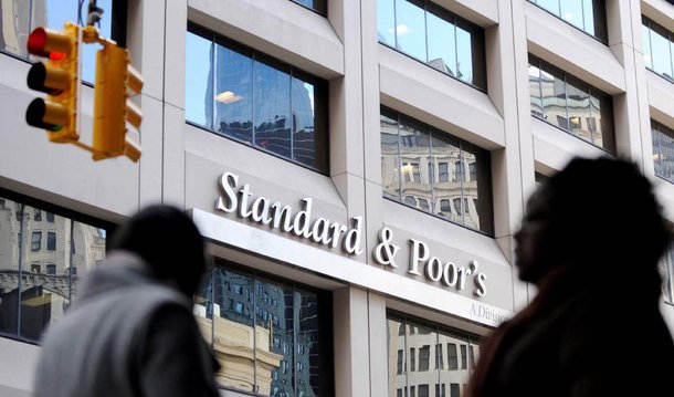 Após rebaixar a nota de crédito do Brasil e de 31 empresas, a agência de classificação de risco Standard &amp; Poor's (S&amp;P) comunicou a redução do rating de 13 instituições financeiras, entre as quais os principais bancos públicos do país; perderam o grau de investimetno a Caixa Econômica Federal, o Banco do Brasil e o Banco Nacional de Desenvolvimento Econômico e Social (BNDES); as notas dessas instituições foram reduzidas de BBB- para BB+, com perspectiva negativa
