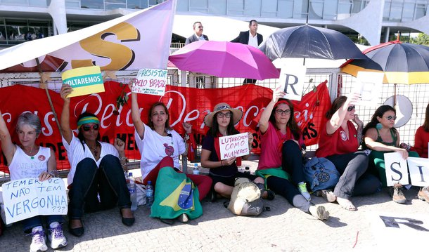 Mulheres se acorrentaram às grades de contenção instaladas no Palácio do Planalto em protesto contra o afastamento da presidente Dilma; elas seguravam faixas e cartazes com a mensagem “resistência contra o golpe”; o grupo disse não ter previsão para deixar o local; o grupo gritava “caraca, a mulherada chegou forte. Está mobilizada, para barrar o golpe”; "Vamos ficar aqui até nos tirarem daqui. Vai ser difícil nos tirar", afirmou uma manifestante que não quis se identificar; as manifestantes também cantavam "mulheres na rua, a luta continua"