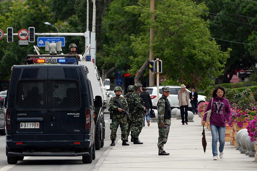 Chinese paramilitary police stand guard along a street in Urumqi, the capital of Xinjiang, on 23 May 2014.