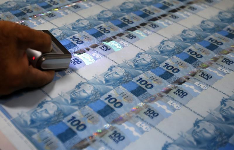 Funcionário verifica folhas de papel-moeda durante uma visita da mídia à Casa da Moeda, no Rio de Janeiro. Com o bom resultado dos governos regionais, o setor público brasileiro surpreendeu e registrou superávit primário de 2,130 bilhões de reais em fever