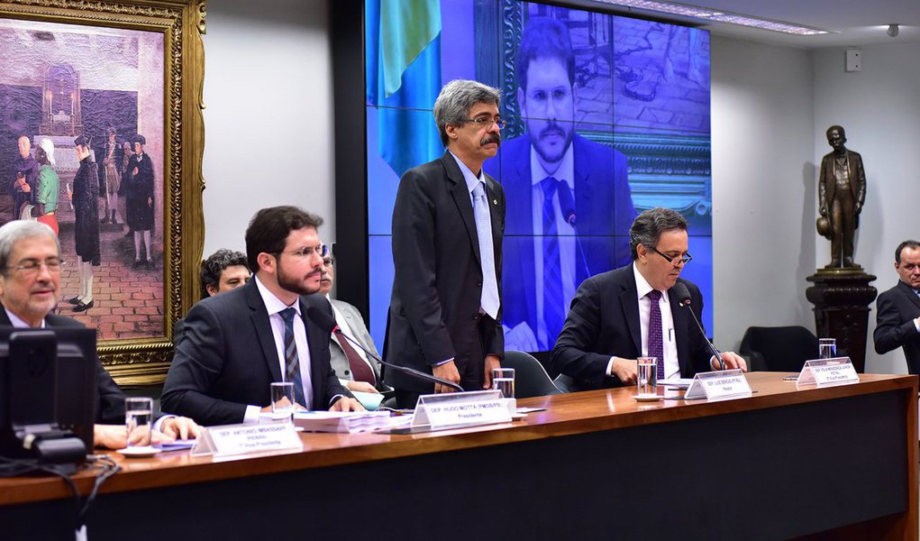 Foram 17 votos a favor, 9 contra e 1 abstenção; o relator, deputado Luiz Sérgio (PT-RJ), defendeu o relatório citando as dificuldades encontrada na condução das investigações:“Durante as investigações pessoas ficaram caladas, a CPI que não teve acesso às delações premiadas e que foram vazadas na mídia”, disse; texto isenta o ex-presidente Lula, a presidente Dilma Rousseff e os ex-presidentes da empresa José Sérgio Gabrielli e Graça Foster; sugere indiciamento de ao menos 70 pessoas, sem incluir políticos, como os ex-diretores da Petrobras Paulo Roberto Costa e Renato Duque, além dos ex-gerentes Pedro Barusco e Venina Velosa