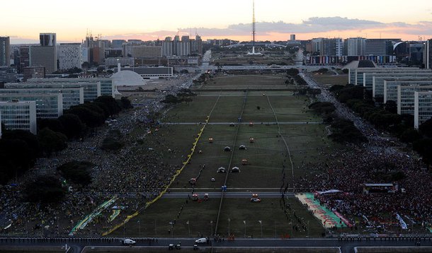 Com medo de confronto, organizadores do protesto em favor do processo de impeachment da presidente Dilma marcaram a viagem de retorno para o fim da tarde deste domingo; de acordo com informações da Polícia Militar, aproximadamente 57 mil manifestantes ocupam a Esplanada dos Ministérios; PMs apreenderam caixas de fogos de artifício na parte de cima de uma árvore no estacionamento do Ministério da Ciência e da Tecnologia, no lado de manifestantes a favor do impeachment; mais de 20 artefatos estavam em uma sacola cheia de folhas; o dono não foi localizado, e ninguém foi preso
