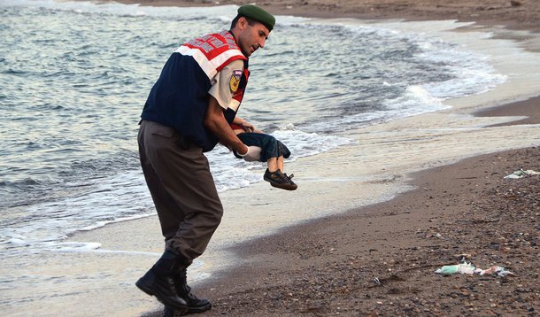 A imagem de uma criança morta por afogamento em uma praia de um dos principais destinos turísticos da Turquia dominou as redes sociais nesta quarta-feira, depois que 12 supostos refugiados sírios morreram tentando chegar à ilha grega de Kos; a foto mostra um menino vestindo uma camisa vermelha e bermudas, com a cabeça afundada na areia; em uma segunda imagem, um policial carrega a criança morta no colo