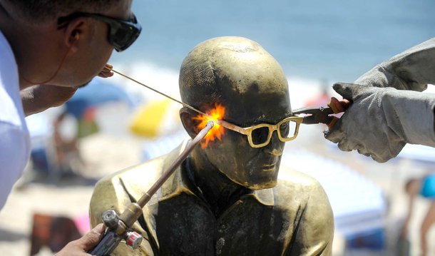 A estátua do poeta Carlos Drummond de Andrade, em Copacabana, na zona sul do Rio de Janeiro, recebeu novos óculos, depois ter o objeto roubado pela nona vez; o monumento, considerado um dos mais expressivos e conhecidos da cidade, também foi alvo de uma ação de conscientização para que novos furtos não ocorram; a multinacional francesa Essilor, que há sete anos adotou a estátua e é responsável por sua manutenção, distribuiu gratuitamente livros do poeta