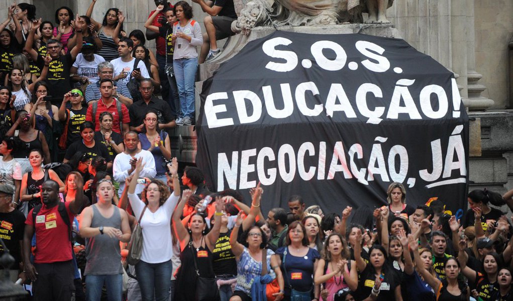 Uma esquete de teatro satirizando a falta de investimentos na educação, na cidade do Rio de Janeiro, e as retaliações que os profissionais alegam ter sofrido depois da greve de 2014, marcou manifestação em frente à sede da prefeitura; cerca de 50 profissionais cobraram esclarecimentos sobre cortes nos salários, que ultrapassam R$ 9 mil em alguns casos, desde o ano passado, e pedem reposição de professores para escolas de ensino fundamental
 