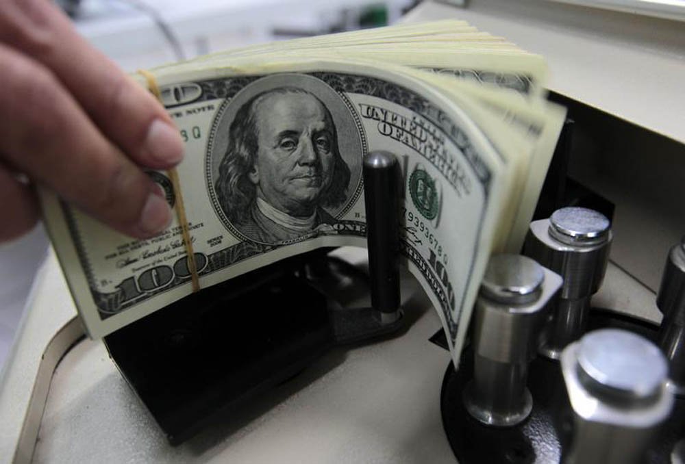Um funcionário de banco conta notas de cem dólares em Bangcoc. O fluxo cambial, entrada e saída e moeda estrangeira do país, ficou negativo em 1,95 bilhões de dólares na semana passada, fazendo com que fevereiro como um todo fechasse no vermelho, com défi