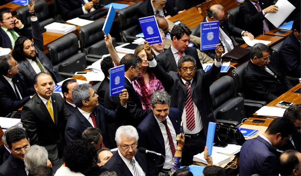 O plenário da Câmara aprovou, por 230 votos a 203, emenda do relator do projeto de lei sobre terceirização (PL 4330/04), deputado Arthur Oliveira Maia (SD-BA), e do PMDB, que muda alguns pontos do texto; além de manter a possibilidade de terceirização da atividade-fim, a emenda diminui de 24 para 12 meses a quarentena que o ex-empregado de uma empresa deve cumprir para que possa oferecer serviços à mesma empresa no âmbito de uma contratada de terceirização; deputados contrários (foto), entre eles parlamentares do PT, levantaram carteiras de trabalho aos gritos de "não à terceirização"