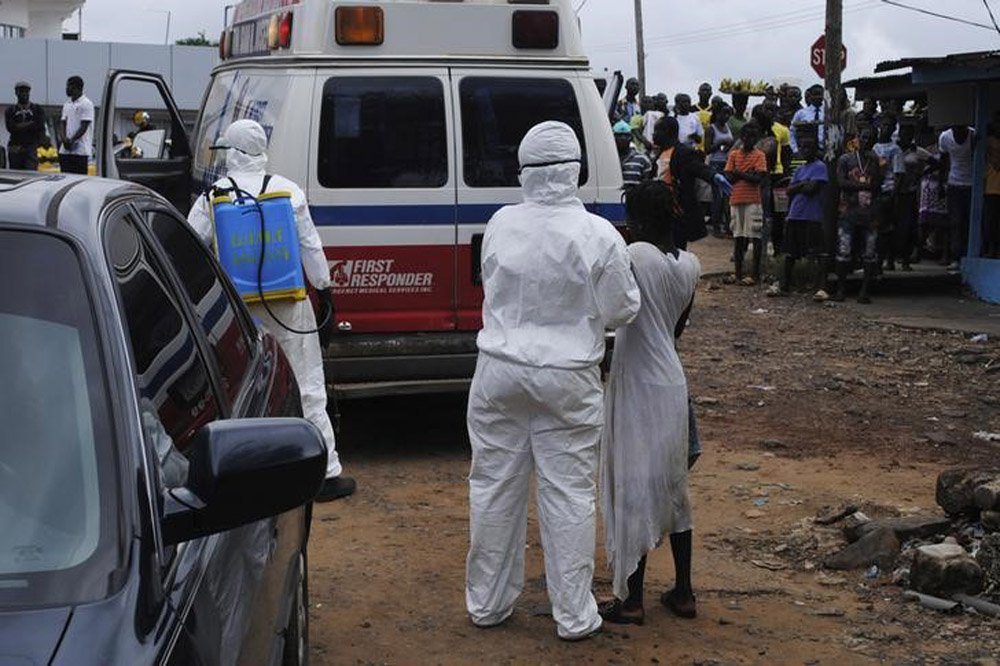 Trabalhadores levam mulher suspeita de estar com Ebola para ambulÃ¢ncia em MonrÃ³via. 15/09/2014 REUTERS/James Giahyue