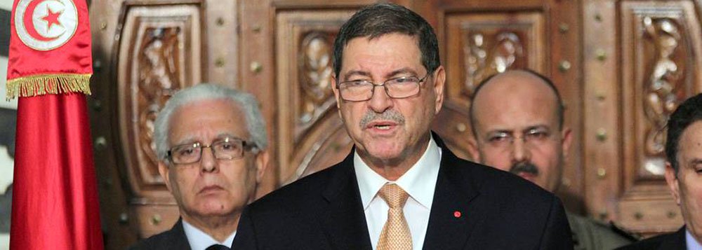 Tunisian Prime Minister Habib Essid (C) speaks during a press conference after an attack carried out by two gunmen at Bardo International Museum on March 18, 2015 in Tunis. At least 17 foreigners were killed, they were among 19 people who died in the atta
