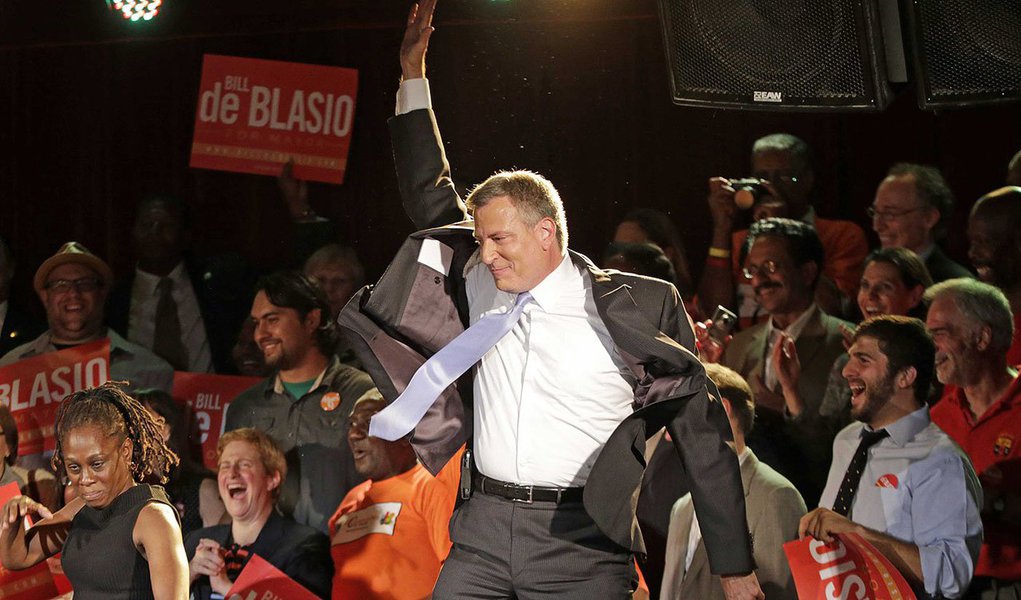 Pesquisas de boca de urna apontam vitória confortável sobre o republicano Joe Lhota, encerrando assim 12 anos de poder de Michael Bloomberg e mais de duas décadas sem eleger um prefeito democrata na cidade; aos 52 anos, o político praticamente desconhecido fez das desigualdades sua grande bandeira eleitoral