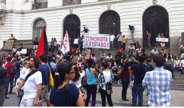 Eles montaram uma barraca, colaram cartazes de protesto no prédio, discursaram contra a violência policial e fizeram um minuto de silêncio pelas pessoas que foram presas na última terça-feira (15), a maioria delas depois de ser cercada por dezenas de policiais militares, que os levaram em ônibus para as delegacias