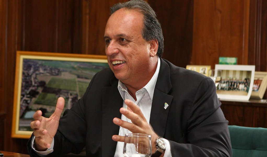 Procuradoria Regional Eleitoral entrou com representação contra vice-governador, o prefeito de Magé, Nestor Vidal; e o deputado estadual Rosenverg Reis, todos do PMDB; Baseada num vídeo feito pela equipe de fiscalização da Justiça Eleitoral, a PRE pede que o Tribunal Regional Eleitoral (TRE) multe os políticos em até R$ 25 mil; a representação é a sétima contra Pezão por antecipação de campanha