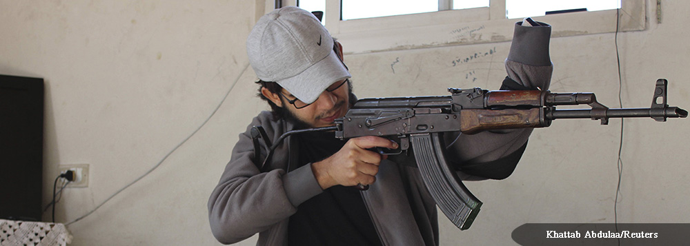 A Free Syrian Army fighter, with an amputated hand, inspects his weapon, at the Jabal al-Akrad area in Syria's northwestern Latakia province October 10, 2013. Picture taken October 10, 2013. REUTERS/Khattab Abdulaa (SYRIA - Tags: CONFLICT)