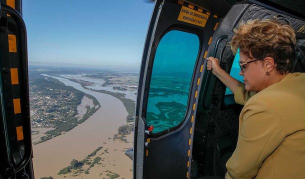 Presidente sobrevoou áreas inundadas e afirmou que o estado receberá os recursos que forem necessários para ações de socorro e assistência às vítimas das enchentes; Dilma Rosuseff esteve em União Vitória, no Sul paranaense; com 53 mil habitantes, município tem 52 mil pessoas atingidas; "Eu nunca tinha visto em áreas urbanas algo nessa proporção, de uma cidade inteira quase desaparecer”, afirmou Dilma, que se comprometeu a analisar a interrupção de maneira temporária do pagamento de impostos federais, segundo acusação do governador Beto Richa (PSDB)