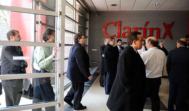O Clarín, maior conglomerado de mídia da Argentina, argumentava que o artigo 161 da lei violava a Constituição ao obrigar a venda de concessões de rádio, TV aberta e TV a cabo previamente adquiridas; com a decisão contrária ao grupo, a empresa precisará vender dezenas de concessões, e se isso não ocorrer o governo poderá leiloá-las; após a sentença, as ações do grupo Clarín tiveram queda de 5,76%, antes que o pregão fosse suspenso na Bolsa de Buenos Aires, à espera de mais informações sobre a decisão; grupo estuda recorrer a tribunais internacionais