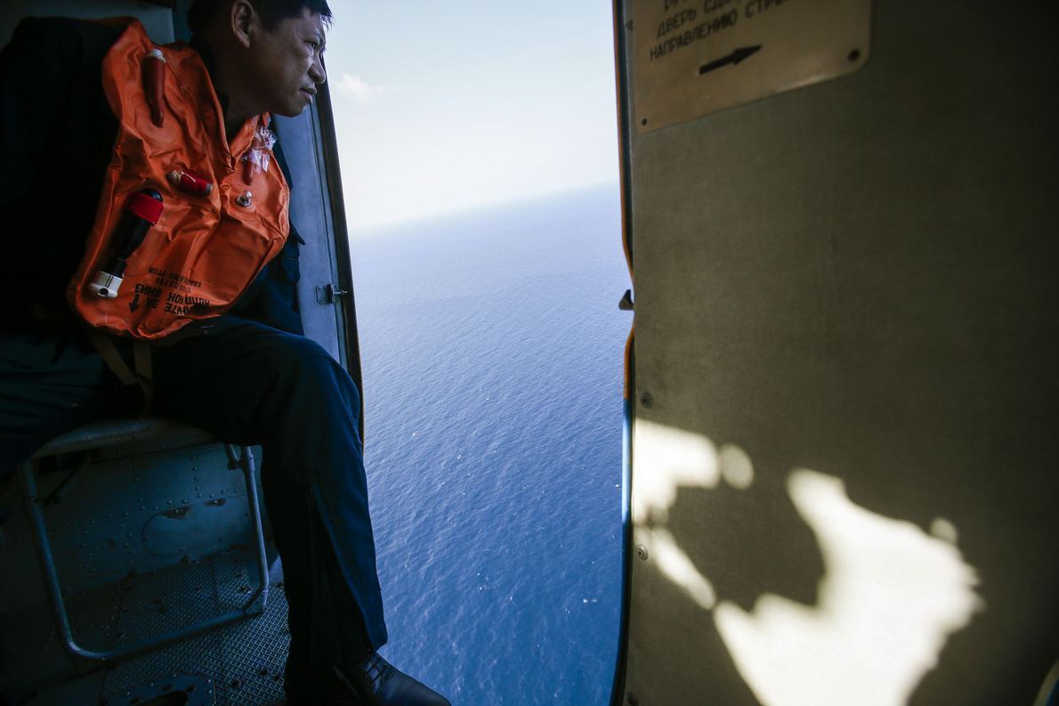 A military personnel looks out of a helicopter during a search and rescue mission off Vietnam's Tho Chu island March 10, 2014. The disappearance of Malaysia Airlines flight MH370, a Boeing 777-200ER jetliner, is an "unprecedented mystery", the country's c