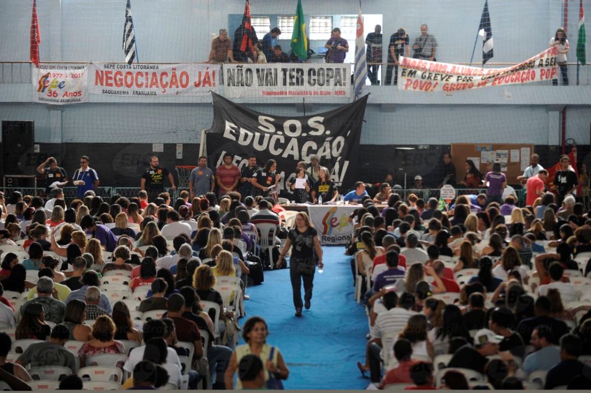 Cerca de 3 mil professores aprovaram, por unanimidade, a continuidade da greve no estado e no município do Rio de Janeiro; a categoria pede reajuste salarial de 20%, redução da jornada semanal de trabalho dos funcionários administrativos para 30 horas e reserva de um terço da carga horária para preparar aula; o próximo passo dos profissionais será escolher uma comissão para negociar com o Poder Público