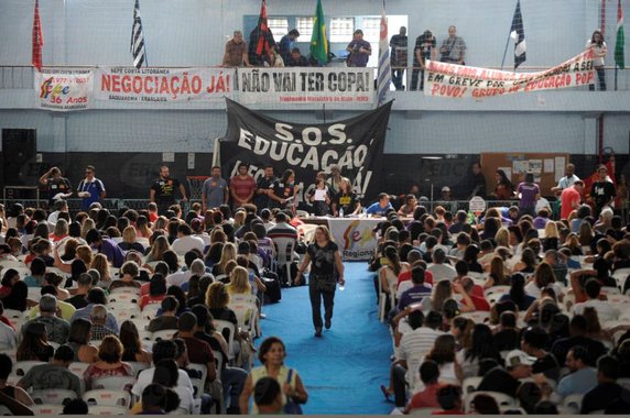 Cerca de 3 mil professores aprovaram, por unanimidade, a continuidade da greve no estado e no município do Rio de Janeiro; a categoria pede reajuste salarial de 20%, redução da jornada semanal de trabalho dos funcionários administrativos para 30 horas e reserva de um terço da carga horária para preparar aula; o próximo passo dos profissionais será escolher uma comissão para negociar com o Poder Público