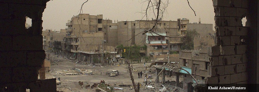 People walking down a street are pictured through a hole in a building in Deir al-Zor April 4, 2013. Picture taken April 4, 2013. REUTERS/ Khalil Ashawi (SYRIA - Tags: CONFLICT TPX IMAGES OF THE DAY)