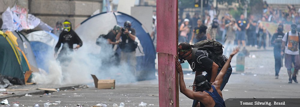 Projeto que cria um novo plano de cargos, carreiras e remuneração para o magistério do Rio foi aprovado em primeira votação por 33 votos a favor e 3 contra, na Câmara de Vereadores; previsão é que o segundo turno ocorra a partir das 18h; na área externa da Câmara, situação é tensa e policiais da Tropa de Choque da Polícia Militar lançam a todo momento bombas de gás lacrimogêneo e de efeito moral em direção aos manifestantes que protestam contra a decisão