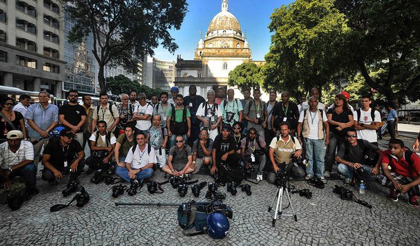 Os jornalistas posicionaram suas câmeras no chão em frente à Delegacia de São Cristóvão, que investiga a mote de Andrade, e fizeram uma oração