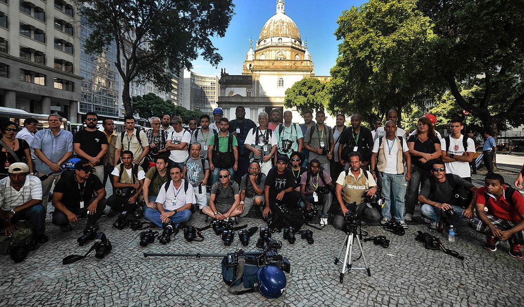 Os jornalistas posicionaram suas câmeras no chão em frente à Delegacia de São Cristóvão, que investiga a mote de Andrade, e fizeram uma oração
